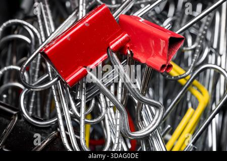 Deux clips à ressort rouges sur les nombreux clips métalliques vue en gros plan. Banque D'Images