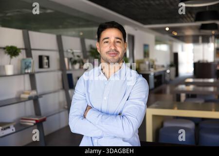 Confiant beau jeune homme professionnel posant dans l'espace de travail de bureau Banque D'Images