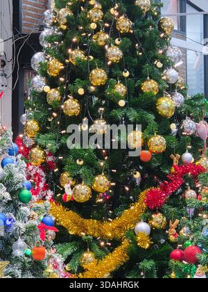 Sapin de noël joyeux avec décoration festive et ornement en or pour les vacances. fond vert avec une lumière étincelante, créant une célébration joyeuse et Banque D'Images