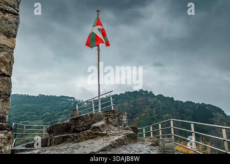 Ikurrina drapeau basque agitant sur San Juan de Gaztelugatxe, Espagne Banque D'Images