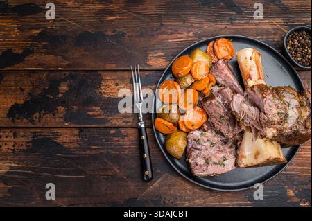 Osso buco de bœuf cuit lentement braisé avec texture de viande juteuse os de moelle et légumes rôtis vue de dessus. Banque D'Images
