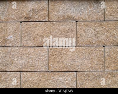 Mur de grès beige avec texture rugueuse, lignes de mortier visibles et motif de bloc horizontal, tons neutres chauds, surface altérée Banque D'Images