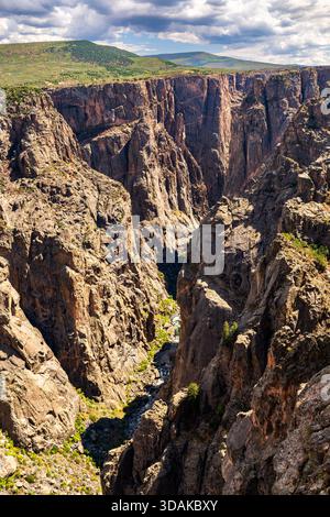 Les parois rocheuses escarpées du Black Canyon du parc national Gunnison s'élèvent au-dessus de la rivière dans le Colorado, aux États-Unis. Paysage spectaculaire avec cli métamorphique foncé Banque D'Images
