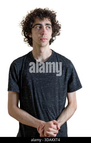 Jeune homme avec les cheveux bouclés debout sur un fond blanc. Banque D'Images