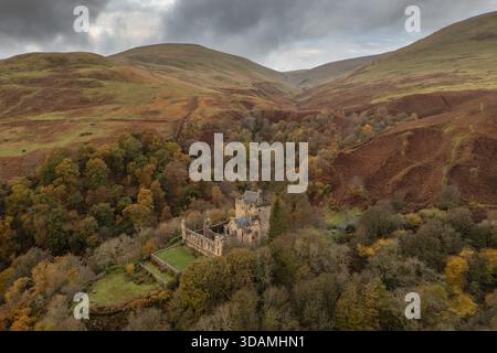 Vue aérienne du château Campbell niché parmi les arbres d'automne colorés à la base des collines d'Ochil sous un ciel nuageux, Dollar, Écosse, United Kin Banque D'Images