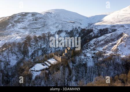 Vue aérienne du château Campbell niché au milieu d'un pays des merveilles hivernales, ses pierres anciennes contrastent avec les collines immaculées couvertes de neige, Dollar, Scotla Banque D'Images
