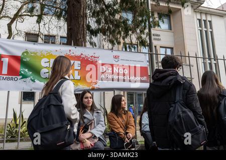 Les étudiants se rassemblent devant l'Escola Secundária Aurélia de Sousa à Porto alors que les cours sont suspendus pendant la grève générale nationale, avec des banderoles de protestation affichées à l'entrée. L’impact de la grève générale nationale appelée par l’UGT et la CGTP. Dès les premières heures du matin, la vie quotidienne a été perturbée : les écoles ont été fermées, les services de métro et de bus ont été interrompus et les hôpitaux ont fonctionné avec un personnel réduit. La grève a remodelé le rythme de la ville, laissant les salles de classe vides, les gares de transport encombrées de retards et les services médicaux sous pression. Banque D'Images