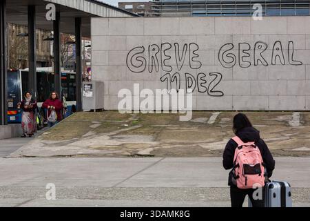 Porto, Portugal. 11 décembre 2025. Une personne passe devant un graffiti lisant « GREVE GERAL 11 DEZ » près d'un arrêt de bus à Porto, car les transports publics sont perturbés pendant la grève générale nationale. L’impact de la grève générale nationale appelée par l’UGT et la CGTP. Dès les premières heures du matin, la vie quotidienne a été perturbée : les écoles ont été fermées, les services de métro et de bus ont été interrompus et les hôpitaux ont fonctionné avec un personnel réduit. La grève a remodelé le rythme de la ville, laissant les salles de classe vides, les gares de transport encombrées de retards et les services médicaux sous pression. Crédit : SOPA images Limited/Alamy Live News Banque D'Images