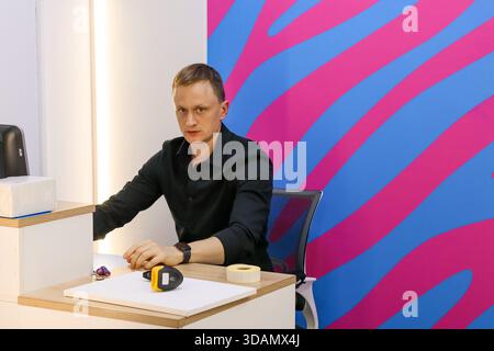 Les bras de l'employé reposent sur le bureau avec le lecteur à l'avant sur le mur rayé Banque D'Images