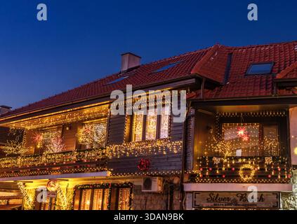 Une charmante maison décorée avec des lumières de Noël chaudes pendant la soirée dans la vieille ville de Nessebar, Burgas, Bulgarie Banque D'Images