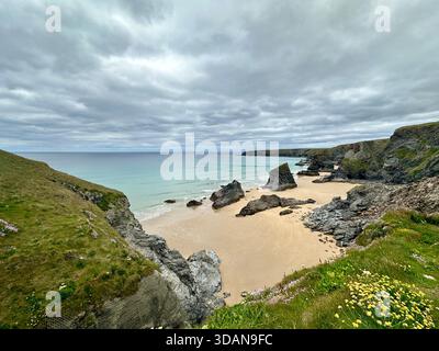 Bedruthan Steps, Cornouailles – majestueuses marches marines et sables dorés sous le ciel sombre de l'Atlantique Banque D'Images