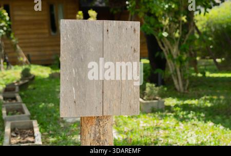 Un panneau blanc en bois altéré sur poteau en bois se trouvant dans un parc vert dans une station rurale. Copier l'espace. Banque D'Images