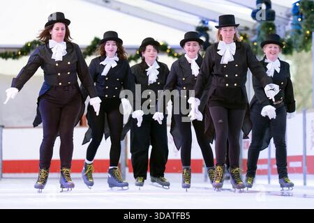 Pour célébrer la Journée mondiale du patinage sur glace le 14 décembre, le personnel des National Galleries of Scotland patine sur glace pour recréer l'une des peintures les plus emblématiques de la collection écossaise, Sir Henry Raeburn's Skating Minister. Faisant équipe avec le Noël d'Édimbourg, les ministres du patinage se sont rendus sur la patinoire de George Street pour imiter le tableau. Peinte vers 1795, l'œuvre porte le nom de Révérend Robert Walker Skating on Duddingston Loch, mais est devenue affectueusement appelée le ministre du patinage. Date de la photo : mardi 9 décembre 2025. Banque D'Images