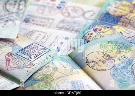 Beaucoup de pages de passeport ouvertes avec beaucoup de visas et de timbres d'entrée de divers pays contrôle des passeports. Concept de voyage et de tourisme dans le monde entier Banque D'Images