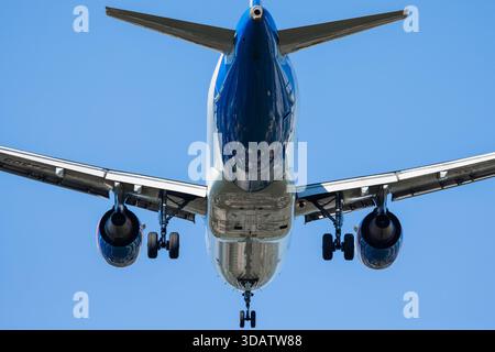 Avion de passagers atterrissant avec train d'atterrissage, vue rapprochée dans le ciel bleu Banque D'Images
