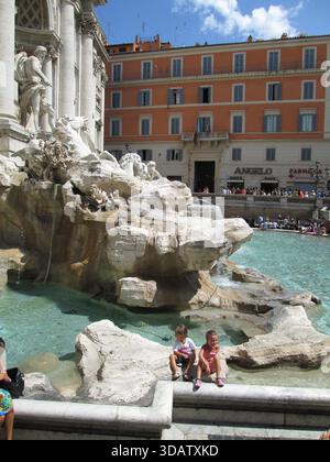 Les visiteurs se rassemblent autour de la fontaine de Trevi à Rome, en Italie, pour admirer les sculptures baroques spectaculaires et les chutes d’eau de l’une des fontaines les plus célèbres et emblématiques du monde 20 août 2013 Banque D'Images