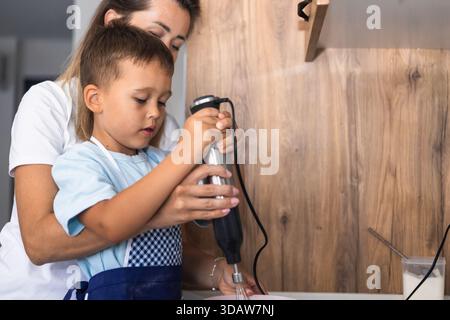 Une mère et son fils profitent d'une délicieuse séance de cuisine à la maison. La scène capture un moment tendre alors qu'ils travaillent ensemble, favorisant la créativité et bo Banque D'Images