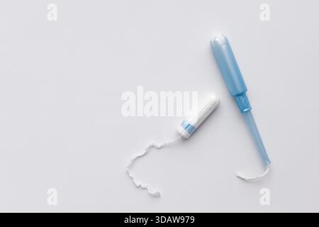 Tampon avec un applicateur bleu sur fond blanc, symbolisant la menstruation et l'hygiène féminine. Produit essentiel pour la santé et le confort des femmes d Banque D'Images