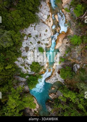 Une vue imprenable sur un drone capture la superbe cascade qui coule à travers le paysage accidenté du Yazili Canyon, entouré d'une végétation dense et de rochers Banque D'Images