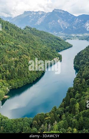 Vue aérienne du lac Levico dans le Trentin, Italie, mettant en valeur des forêts luxuriantes et des montagnes majestueuses. Les eaux tranquilles et le paysage verdoyant créent une idy Banque D'Images