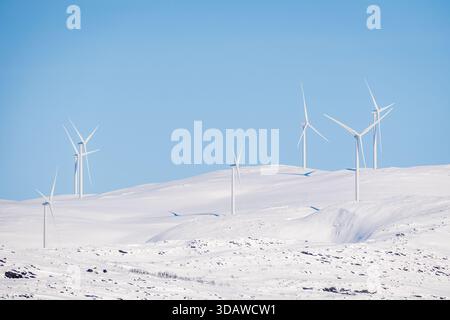 Une rangée d'éoliennes se dresse contre un paysage norvégien enneigé, à Kvaloysletta. Ces structures exploitent la puissance du vent, contribuant au su Banque D'Images