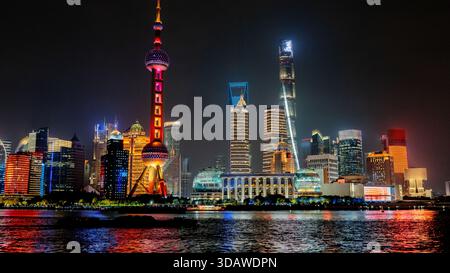 Vue imprenable sur les gratte-ciel emblématiques de Shanghai la nuit, avec la Tour de la perle orientale illuminée et les gratte-ciel modernes reflétant la rivière Huangpu Banque D'Images