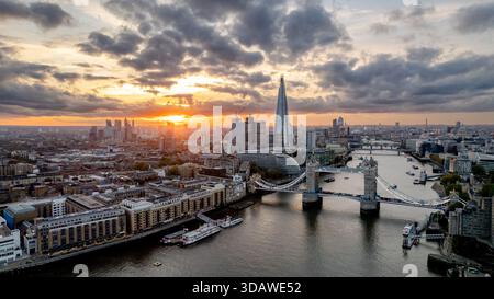Une vue aérienne époustouflante de Tower Bridge avec l'emblématique Shard en arrière-plan lors d'un coucher de soleil vibrant sur Londres. Le paysage urbain présente un arc moderne Banque D'Images
