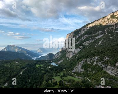 Vue aérienne sur les superbes Dolomites présentant des falaises escarpées, de vastes forêts et une vallée sereine. Le paysage est baigné de lumière douce du jour, acce Banque D'Images