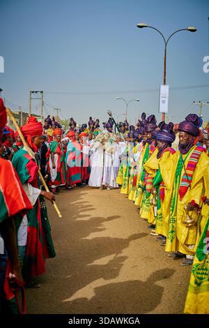 Kano, Nigeria - 17 mars 2022 : vue d'hommes en tenue traditionnelle vibrante se rassemblent le long de Maiduguri Road, leurs robes colorées créant un contras saisissant Banque D'Images