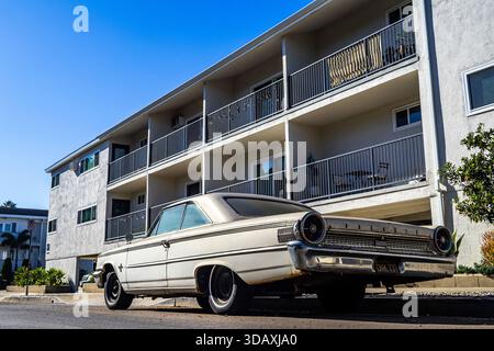 Voiture ancienne 1963 Ford Galaxie 500 garée dans un immeuble d'appartements de style dingbat à Los Angeles, avec des places de parking « soft story », architecture rétro Banque D'Images