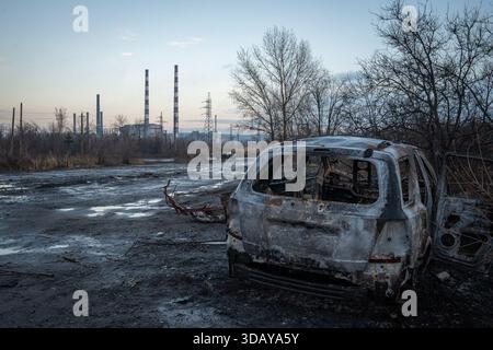 Mykolaivka, oblast de Donetsk, Ukraine. 12 décembre 2025. Une voiture incendiée, percutée par une frappe russe de FPV, se trouve près du bord de la route, avec la centrale électrique visible en arrière-plan. (Crédit image : © Tommaso Fumagalli/ZUMA Press Wire) USAGE ÉDITORIAL SEULEMENT ! Non destiné à UN USAGE commercial ! Banque D'Images