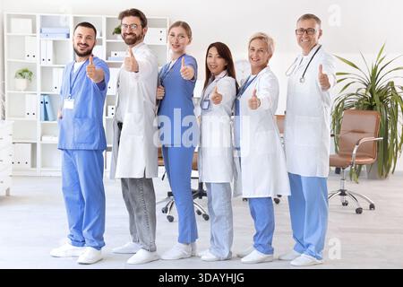 Équipe de médecins montrant les pouces vers le haut en clinique Banque D'Images
