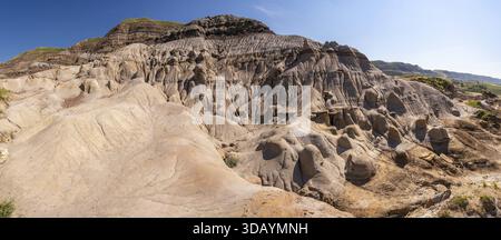 Vue panoramique des formations rocheuses hoodoo uniques à drumheller, en alberta, mettant en valeur les merveilles géologiques des badlands canadiens sous un bleu clair Banque D'Images