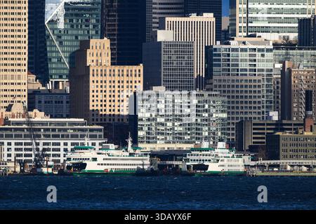 Seattle - 7 décembre 2025 ; paire de ferries de l'État de Washington amarrés devant les bâtiments du centre-ville de Seattle Banque D'Images