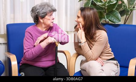 Grand-mère petite-fille visite parler dans la maison de retraite Banque D'Images
