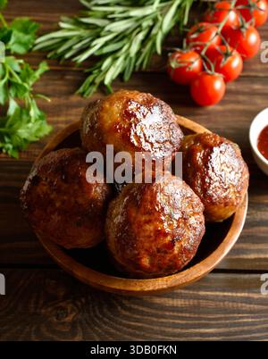Côtelettes maison savoureuses de viande hachée dans un bol sur fond en bois. Vue rapprochée Banque D'Images