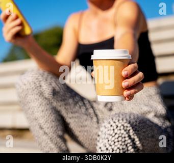 Femme urbaine tenant la tasse de café à emporter à l'extérieur dans la ville pour la conception de marque Banque D'Images