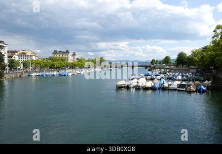 Vue vers le pont du Quai sur la rivière Limmat à Zurich, Suisse, bateaux à moteur et voiliers sur le quai. Zurich, Suisse- 17 mai 2025 : vue vers le pont du quai sur la rivière Limmat, bateaux à moteur et voiliers sur le quai, les gens marchant le long de la promenade du front de mer et traversant le pont. Bâtiments en arrière-plan à gauche, été, jour nuageux. Edit switzerland zurich B97A8282 Banque D'Images