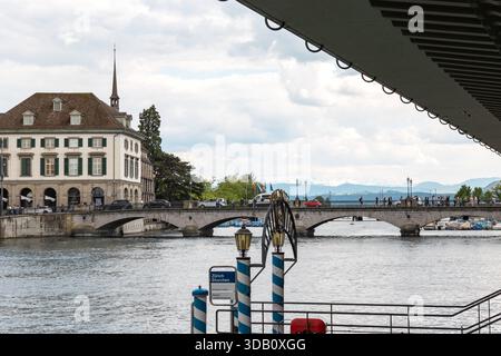 Suisse, Zurich, vue sur le pont Münster sur la rivière Limmat. Zurich, Suisse 17 mai 2025 : vue sur le pont Münster au-dessus de la Limmat. Bâtiments et personnes en arrière-plan, été, jour nuageux. Edit switzerland zurich B97A8277 Banque D'Images
