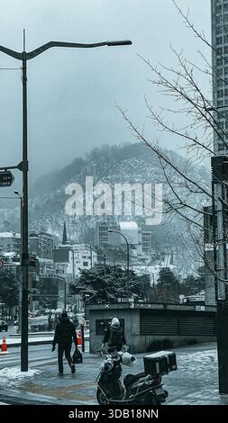 Scène de rue à Séoul avec piétons et montagne enneigée en toile de fond Banque D'Images