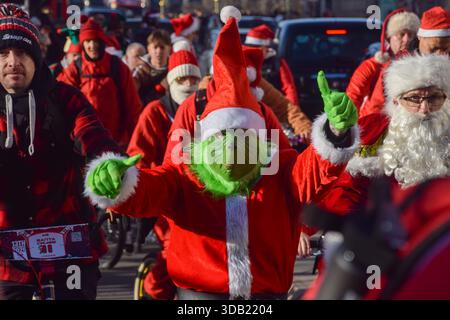 Londres, Royaume-Uni. 13 décembre 2025. Un participant porte un costume Grinch alors que des centaines de cyclistes habillés en Père Noël et d'autres personnages de Noël participent à la croisière Santa Cruise 2025 de BMX Life, collectant des fonds pour l'organisme de bienfaisance ECHO (Evelina Children's Heart Organisation). Crédit : Vuk Valcic/Alamy Live News Banque D'Images