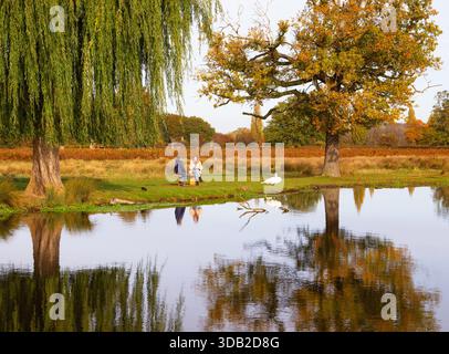 Deux femmes parlant à côté de l'étang Heron à Bushy Park, Londres, Angleterre Banque D'Images