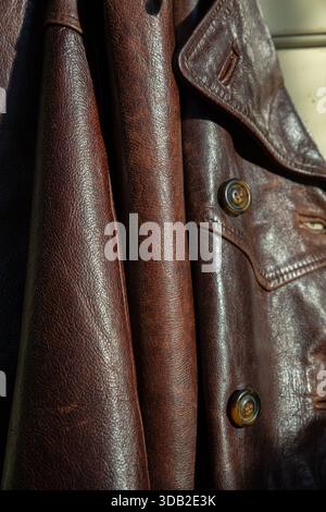 Photographie détaillée en gros plan d'une veste en cuir marron vintage mettant en valeur le savoir-faire des éléments de design classiques. L'image présente un prominen Banque D'Images