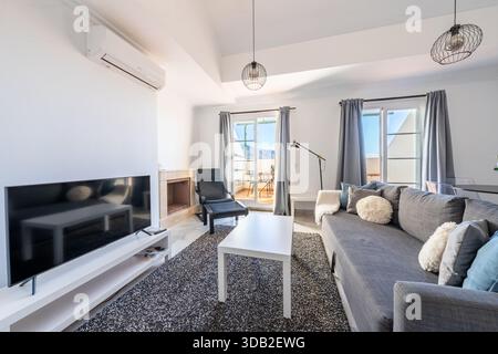 Intérieur de salon avec canapé gris et balcon dans un appartement méditerranéen Banque D'Images