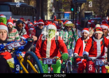 Londres, Royaume-Uni. 13 décembre 2025. Un participant porte un costume de Grinch alors que des centaines de cyclistes habillés en Père Noël et d'autres personnages de Noël participent à la croisière du Père Noël de BMX Life, collectant des fonds pour l'organisation caritative ECHO (Evelina Children's Heart Organisation). Crédit : SOPA images Limited/Alamy Live News Banque D'Images