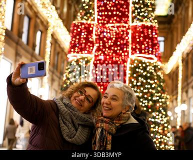 Rome, Italie. 13 décembre 2025. Les gens prennent des selfies avec des lumières festives à la Galleria Alberto Sordi à Rome, Italie, Dec. 13, 2025. Crédit : Li Jing/Xinhua/Alamy Live News Banque D'Images