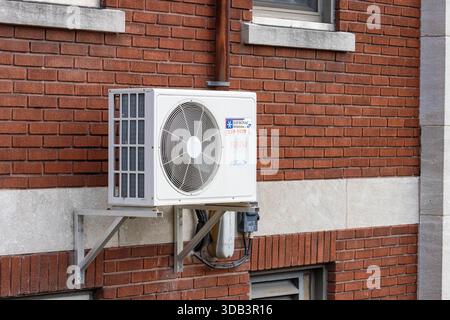 Canada, Québec, 08 novembre 2025 : unité de climatisation sur mur de briques rouges avec poutres de support métalliques Banque D'Images