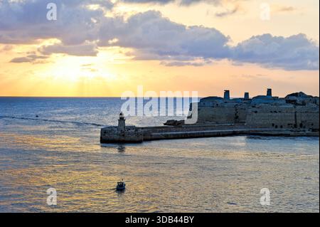 Coucher de soleil sur Fort Ricasoli à l'entrée du Grand Port à la Valette, Malte, Europe du Sud Banque D'Images
