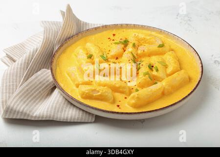 Gâteaux de riz coréen tteokbokki dans une sauce crémeuse au fromage Banque D'Images