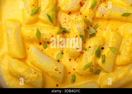 Gâteaux de riz coréen tteokbokki dans une sauce crémeuse au fromage Banque D'Images